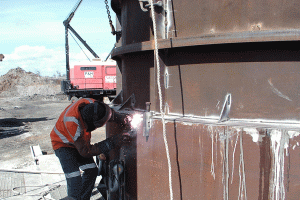 Man welding liners into place for mine vent shaft
